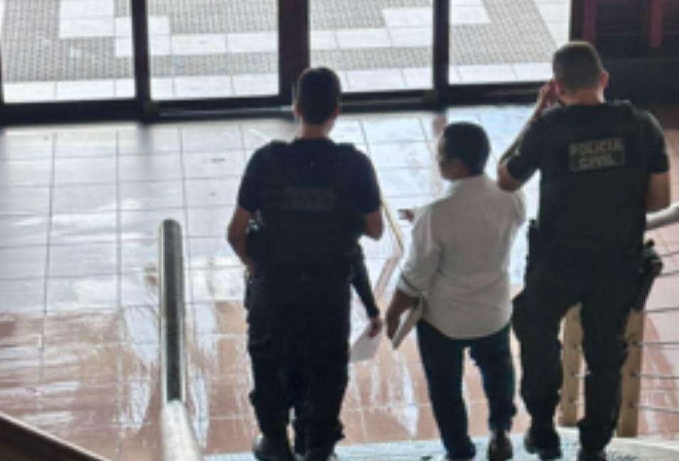 A imagem em destaque mostra o suspeito sendo conduzido por policiais civis